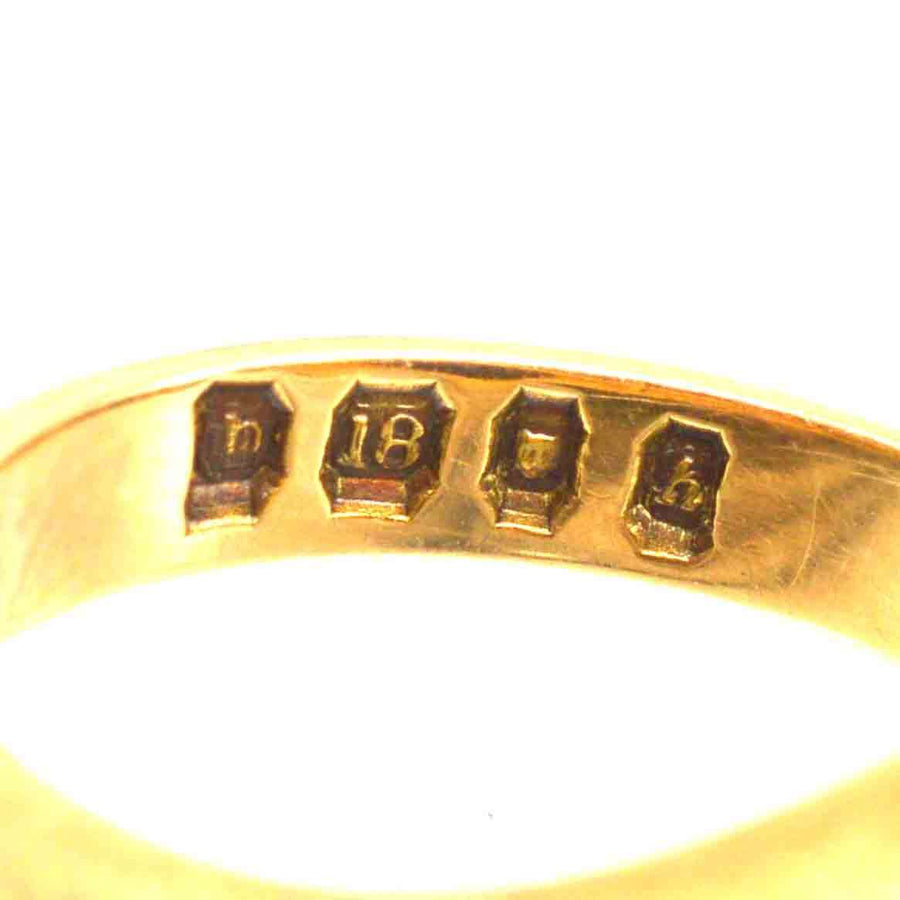 Close-up of 18ct gold signet ring hallmarks, showcasing quality craftsmanship and authenticity.