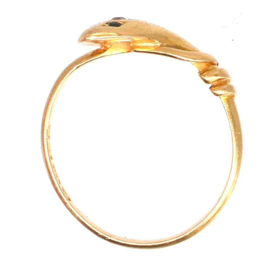 Edwardian 18ct gold snake ring with green garnet eyes, showcasing intricate craftsmanship and elegant design.