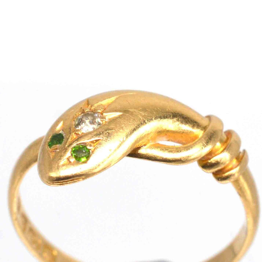 Edwardian 18ct gold snake ring with diamond and green garnet eyes, showcasing elegant craftsmanship.