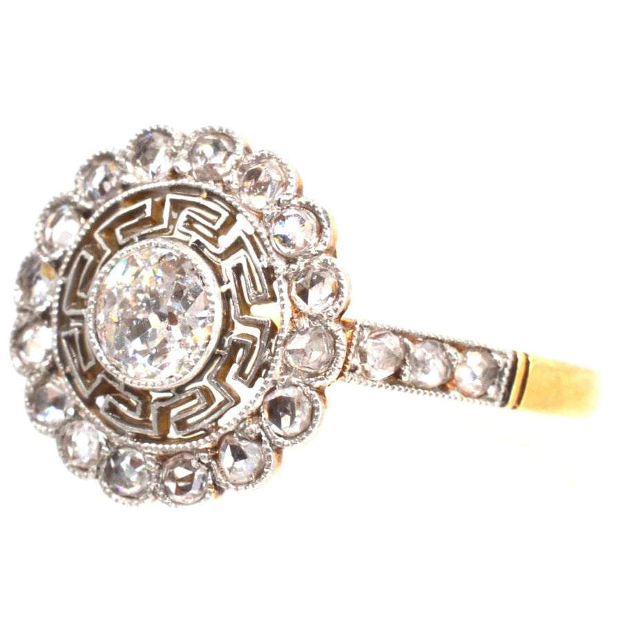 Art Deco 18ct gold and platinum diamond target ring with Greek key details, vintage style.
