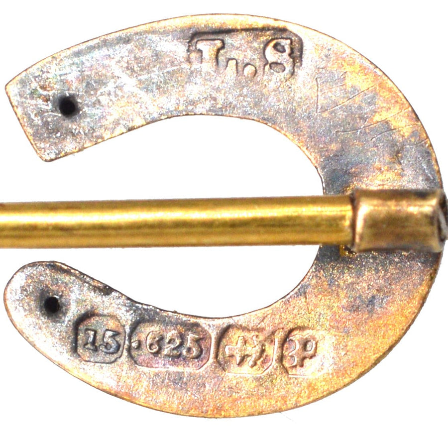 Close-up of a Victorian 15ct gold horseshoe tie pin, with hallmark details and a gold clasp.