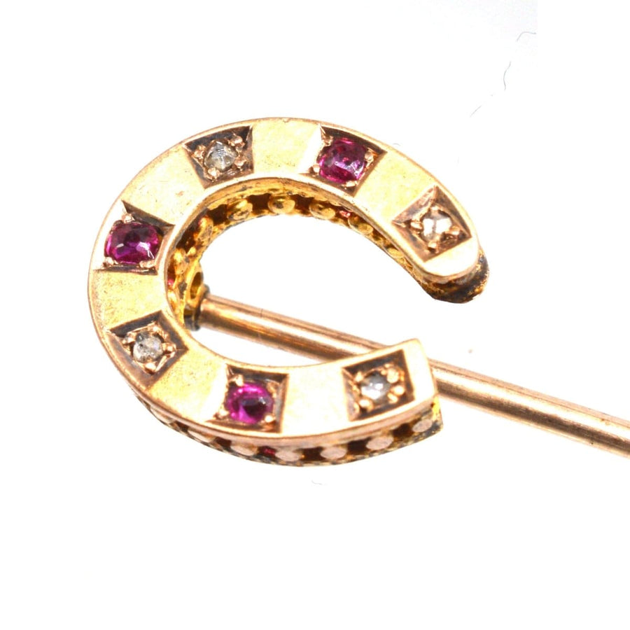 Victorian 15ct gold horseshoe tie pin adorned with rubies and diamonds, symbolizing luck and elegance.