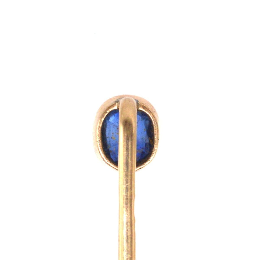 Close-up of a vintage Austro-Hungarian 14ct gold tie pin featuring a vibrant blue sapphire, showcasing fine craftsmanship.