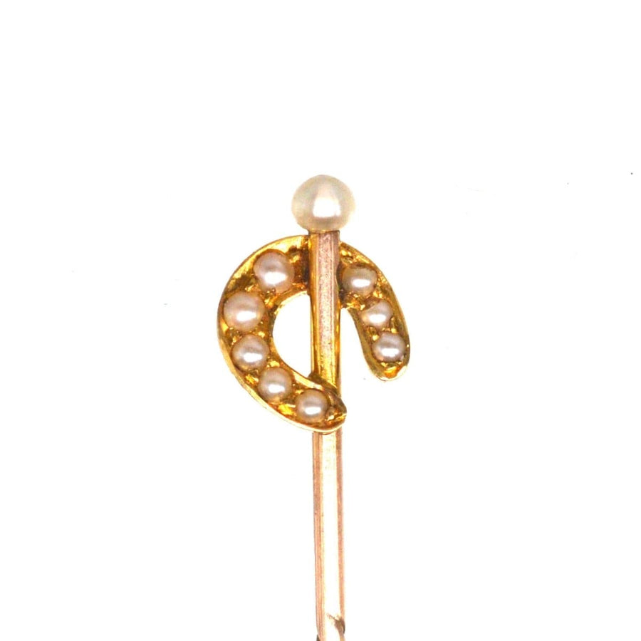 Edwardian 15ct gold horseshoe tie pin with natural pearls, symbolizing good luck and protection.