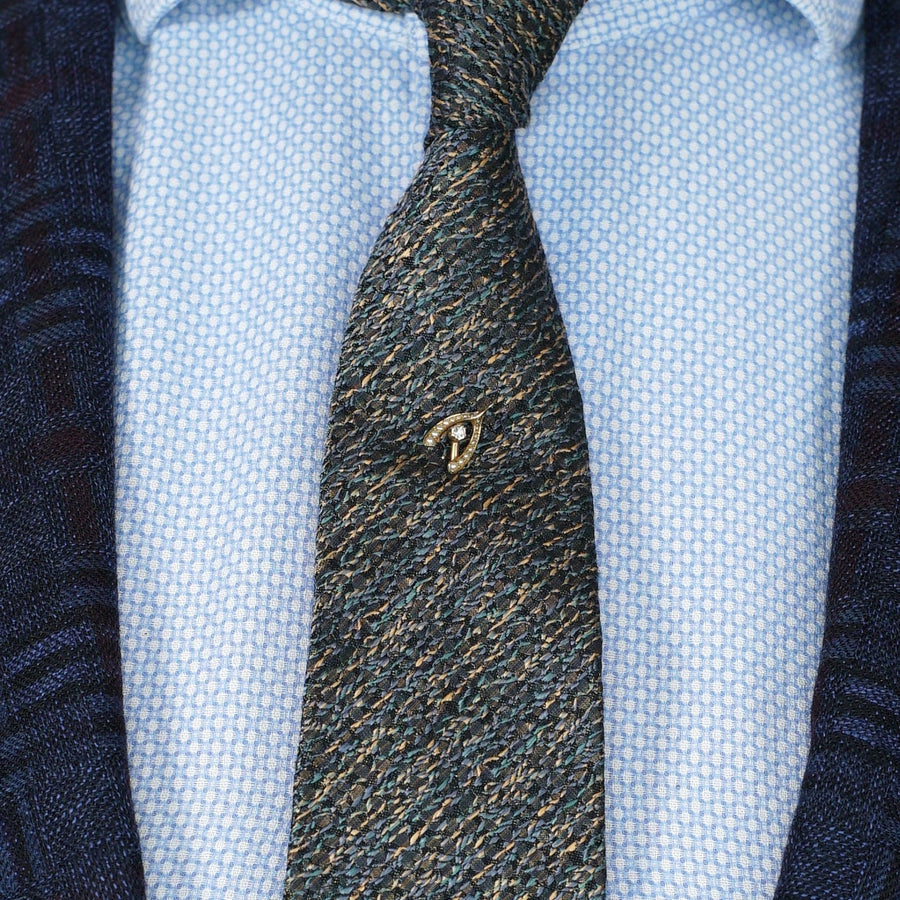 Edwardian 15ct gold wishbone tie pin adorned with seed pearls and diamond, stylishly positioned on a tie.