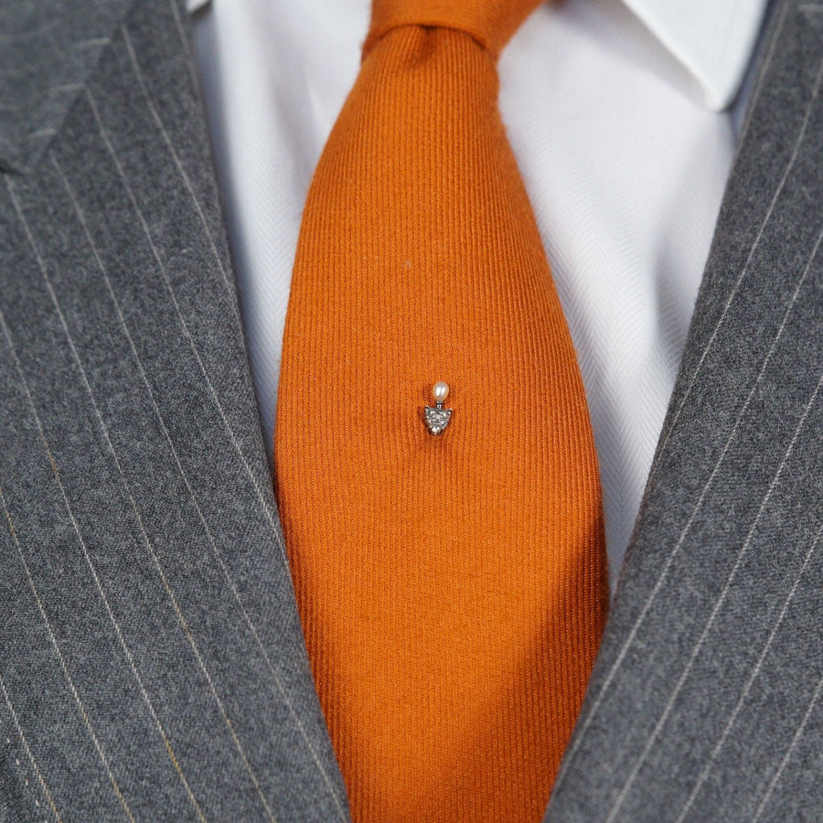 Edwardian 15ct gold and silver tie pin with rose diamond and natural pearl on an orange silk tie.