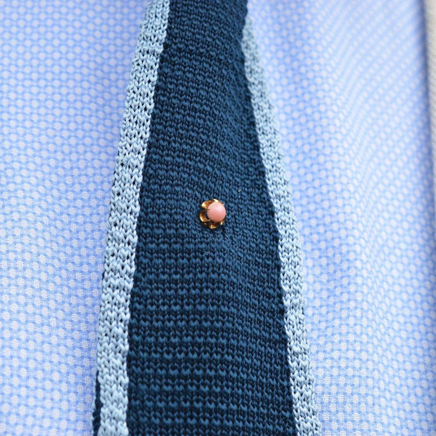 Victorian 18ct gold conch pearl tie pin featured on a knitted navy blue tie.